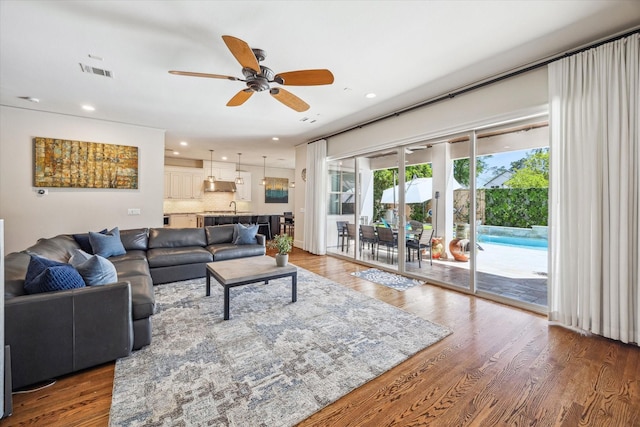 living room with recessed lighting, ceiling fan, visible vents, and wood finished floors