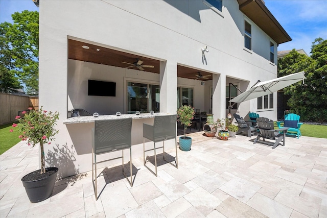 view of patio / terrace with fence, a ceiling fan, and outdoor wet bar