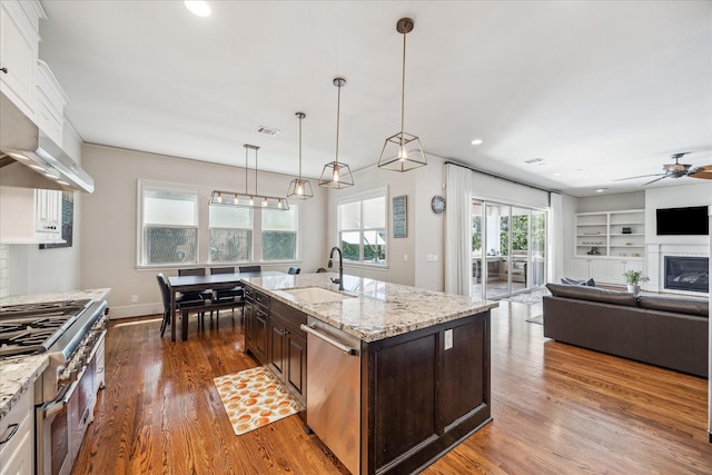 kitchen with a sink, appliances with stainless steel finishes, ceiling fan, and wood finished floors