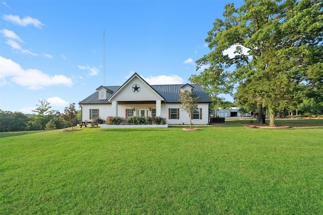 view of front of house featuring a standing seam roof, metal roof, and a front yard