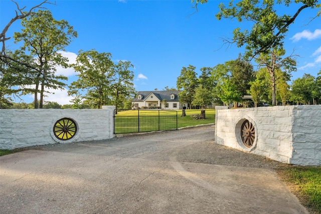 view of street with driveway and a gated entry