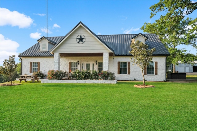 view of front of home with a front lawn, stone siding, and metal roof