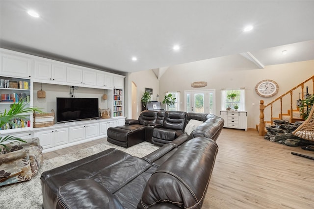 living area with recessed lighting, light wood finished floors, lofted ceiling, and stairs