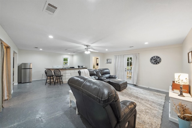 living room with a healthy amount of sunlight, recessed lighting, and visible vents