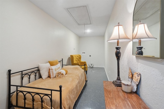 bedroom featuring baseboards and attic access