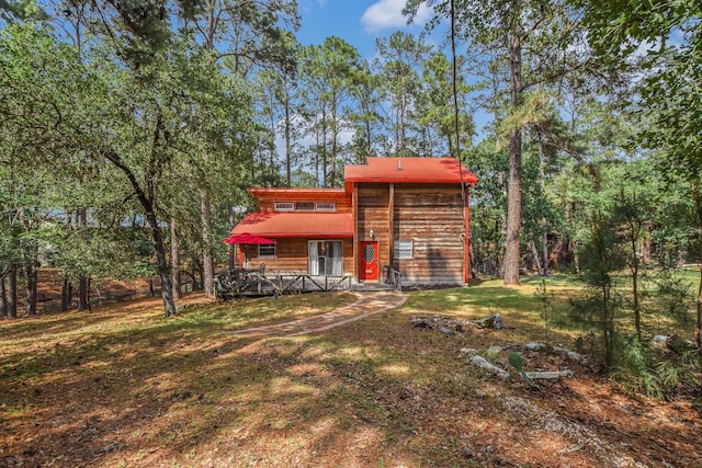 rear view of property featuring a lawn and a wooden deck