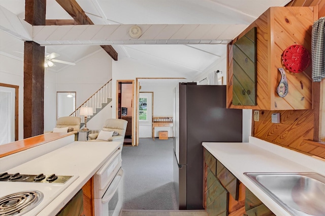 kitchen featuring a sink, white appliances, vaulted ceiling with beams, light countertops, and carpet flooring