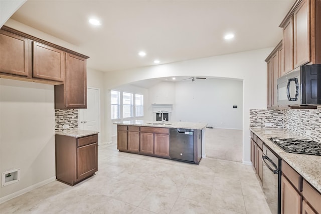 9135 Monarch Field Ln, Cypress, TX 77433 - kitchen featuring light stone countertops, open floor plan, arched walkways, backsplash, and black appliances