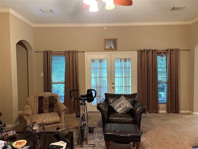 8813 Lauren Ln, Waller, TX 77484 - carpeted living room with crown molding, arched walkways, ceiling fan, and visible vents