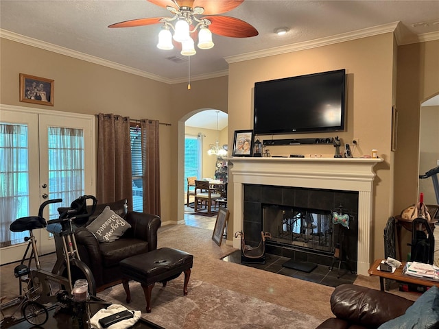 8813 Lauren Ln, Waller, TX 77484 - carpeted living area featuring ceiling fan, visible vents, arched walkways, a fireplace, and ornamental molding