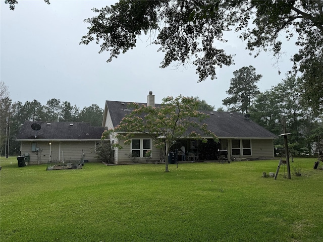 8813 Lauren Ln, Waller, TX 77484 - back of property with a lawn and a chimney