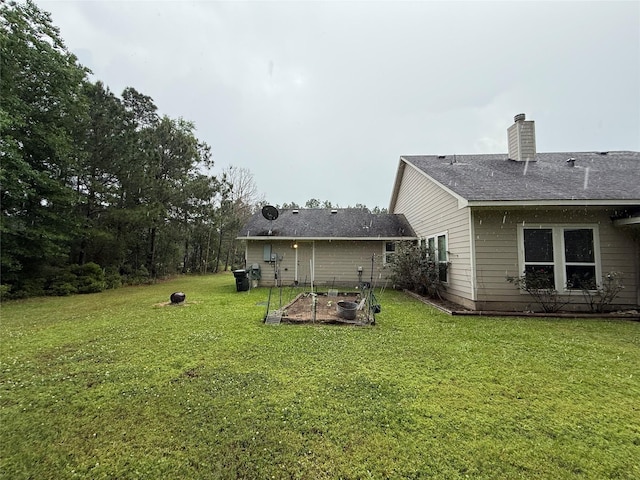 8813 Lauren Ln, Waller, TX 77484 - back of property featuring a shingled roof, a garden, a yard, and a chimney