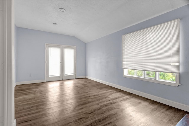 331 Terminal St, Houston, TX 77020 - unfurnished room featuring baseboards, wood finished floors, vaulted ceiling, and french doors