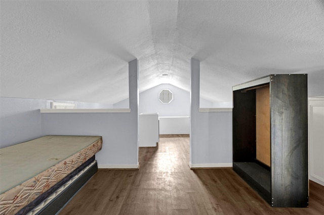 331 Terminal St, Houston, TX 77020 - unfurnished bedroom with a textured ceiling, baseboards, vaulted ceiling, and wood finished floors
