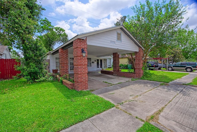 331 Terminal St, Houston, TX 77020 - view of front of property featuring a front lawn, fence, brick siding, driveway, and a carport