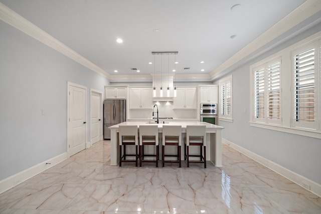 kitchen with crown molding, a kitchen breakfast bar, an island with sink, stainless steel appliances, and baseboards