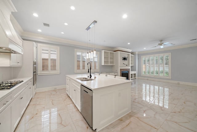 kitchen featuring a center island with sink, a sink, marble finish floor, ornamental molding, and stainless steel appliances