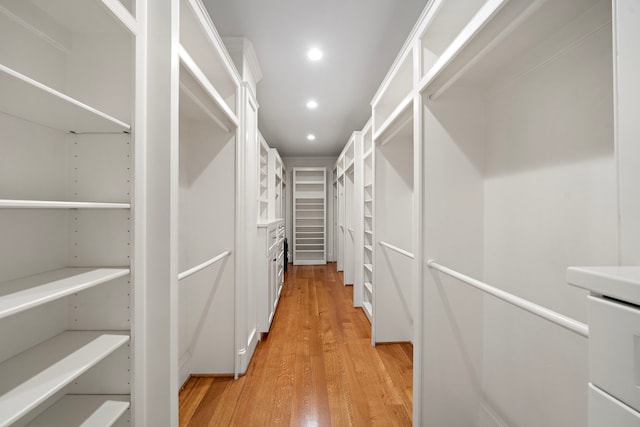 walk in closet with light wood-style flooring