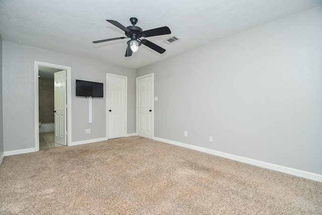 709 N Rivershire Dr, Conroe, TX 77304 - unfurnished bedroom with visible vents, light carpet, baseboards, ceiling fan, and connected bathroom