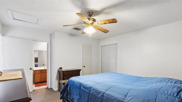 bedroom with a ceiling fan, attic access, visible vents, connected bathroom, and dark carpet