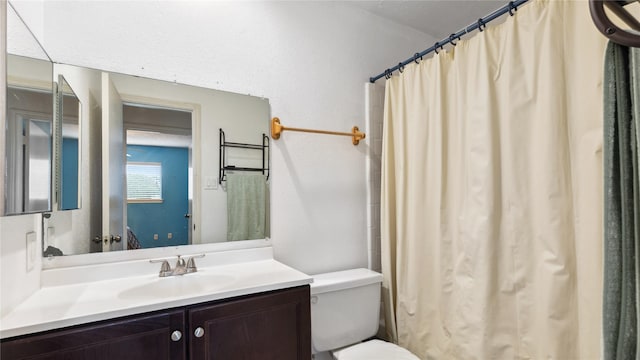 bathroom featuring toilet, curtained shower, and vanity