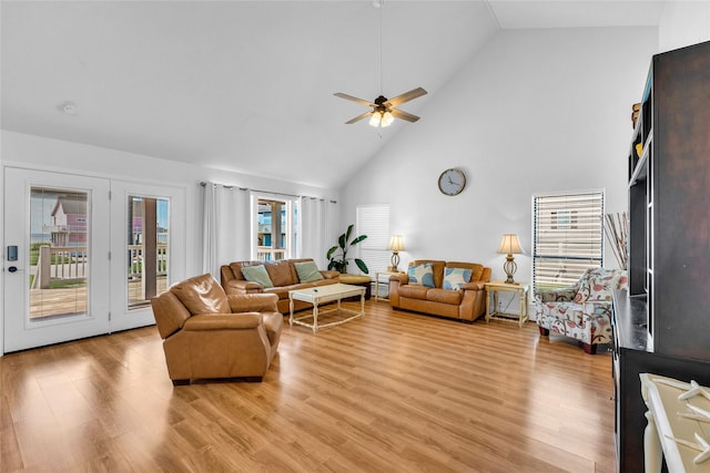living room with high vaulted ceiling, ceiling fan, and light wood finished floors