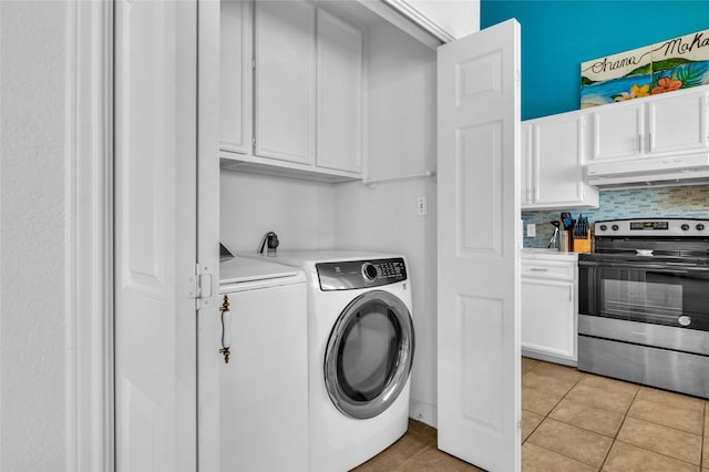 clothes washing area with laundry area, washer and clothes dryer, and light tile patterned floors
