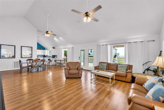 living area with ceiling fan, visible vents, high vaulted ceiling, and light wood-style floors