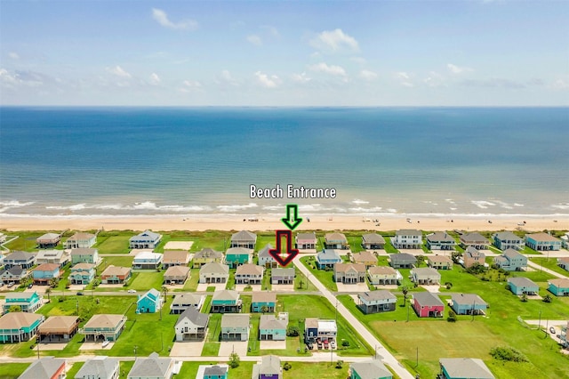 drone / aerial view featuring a beach view, a residential view, and a water view