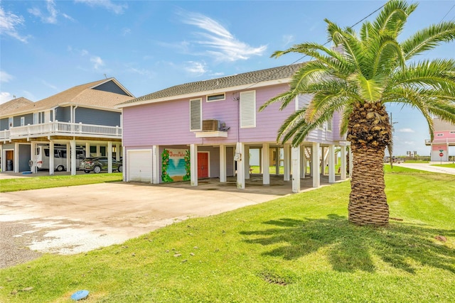 beach home with roof with shingles, a garage, a front yard, a carport, and driveway
