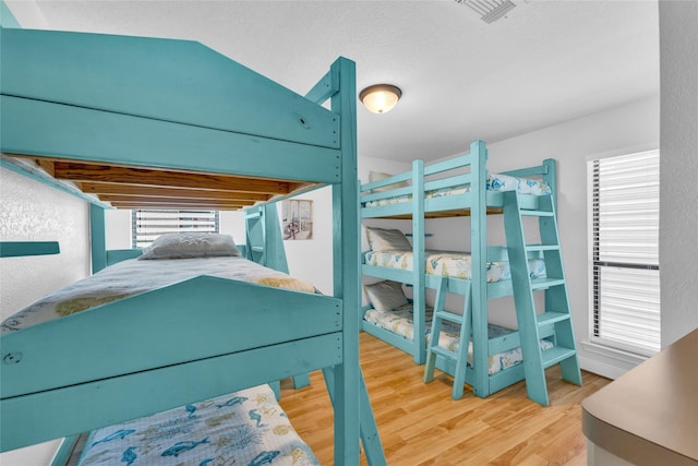 bedroom featuring wood finished floors and visible vents