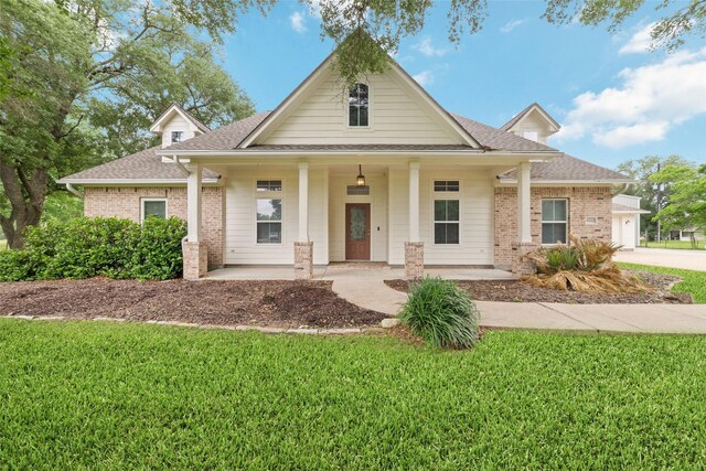 6820 Cemetary Rd, Manvel, TX 77578 - view of front facade featuring roof with shingles, covered porch, brick siding, a front lawn, and concrete driveway