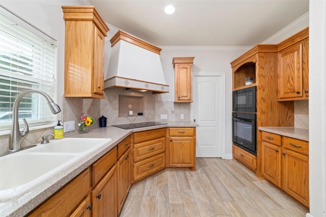 6820 Cemetary Rd, Manvel, TX 77578 - kitchen with a sink, black appliances, light countertops, ornamental molding, and light wood-type flooring