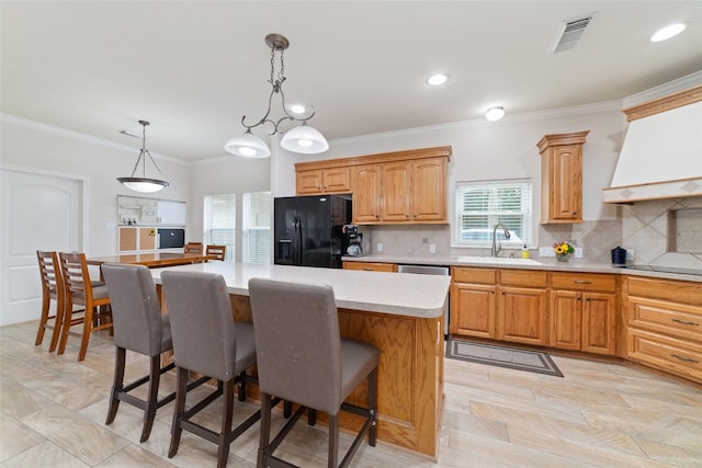 6820 Cemetary Rd, Manvel, TX 77578 - kitchen featuring black fridge, a sink, healthy amount of natural light, light countertops, and ornamental molding