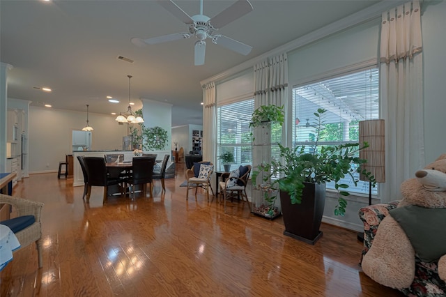 living area featuring visible vents, wood finished floors, baseboards, recessed lighting, and ceiling fan with notable chandelier