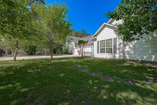 view of yard featuring a garage and concrete driveway