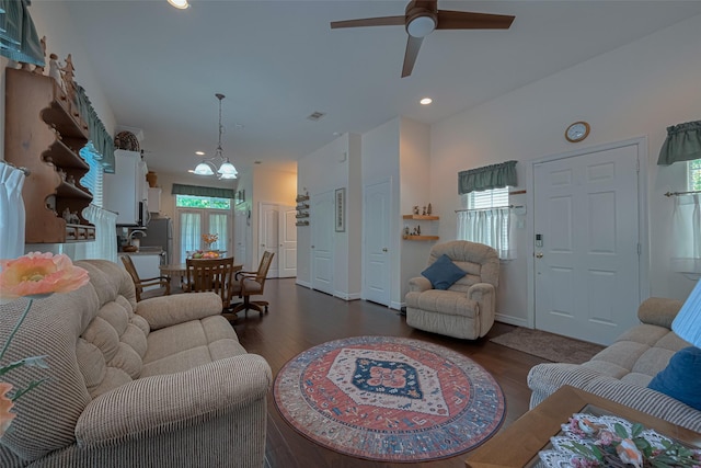 living room featuring a healthy amount of sunlight, ceiling fan with notable chandelier, recessed lighting, and dark wood-type flooring