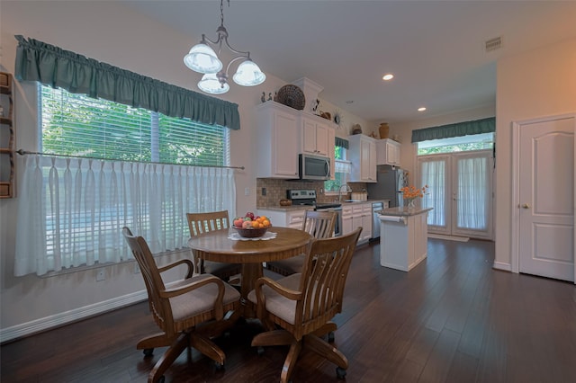 dining space with dark wood-style flooring, a notable chandelier, recessed lighting, baseboards, and visible vents