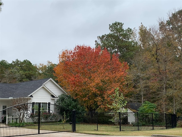 view of side of home with a yard, fence private yard, and driveway
