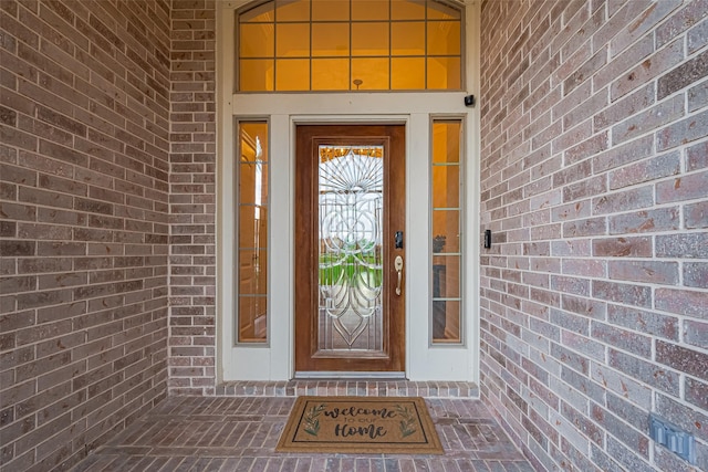 doorway to property featuring brick siding