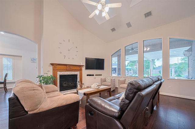 living room with dark wood-style flooring, arched walkways, high vaulted ceiling, a ceiling fan, and visible vents