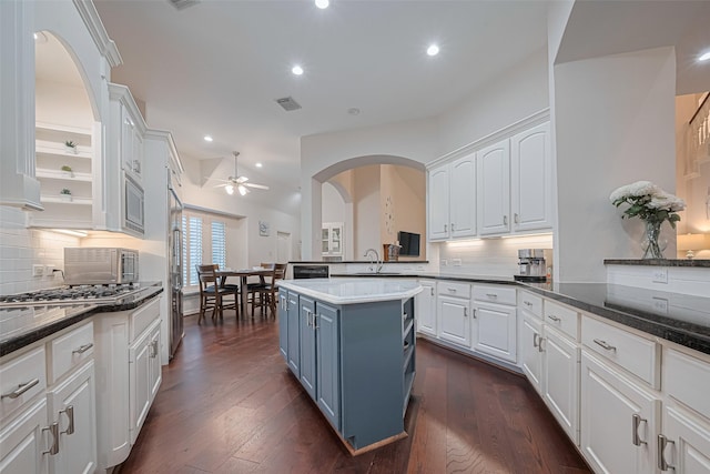 kitchen featuring a ceiling fan, decorative backsplash, and white cabinets