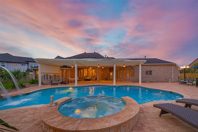 pool at dusk with a patio, a pool with connected hot tub, and a pergola