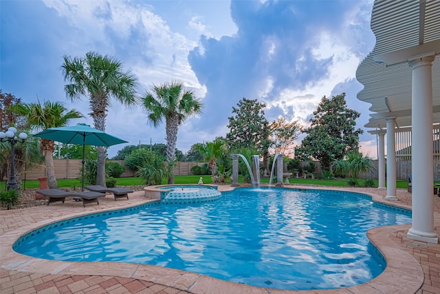 view of pool featuring a patio, a pool with connected hot tub, and a fenced backyard