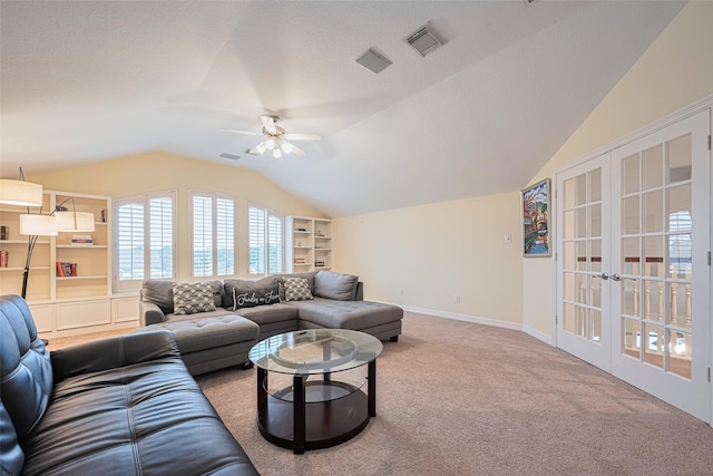 living area with french doors, a ceiling fan, visible vents, vaulted ceiling, and carpet floors