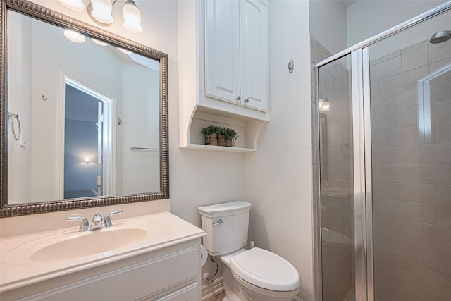 bathroom featuring vanity, a stall shower, and toilet