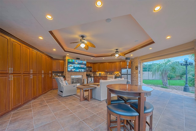 living room featuring recessed lighting, a ceiling fan, a raised ceiling, and light tile patterned flooring