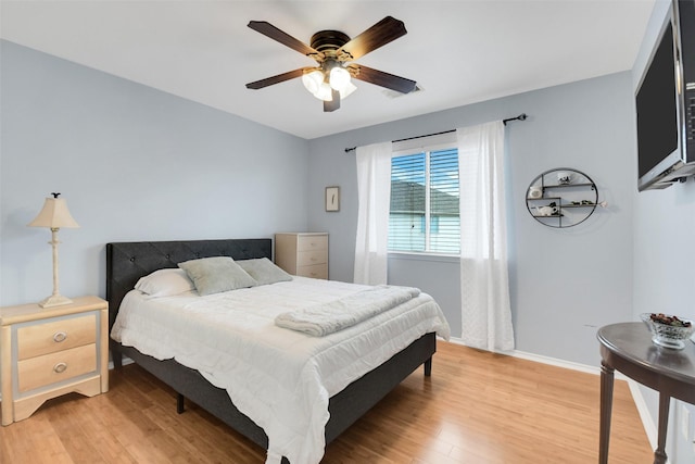bedroom featuring light wood-type flooring, baseboards, and ceiling fan