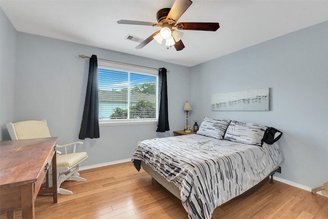 bedroom with visible vents, baseboards, and wood finished floors