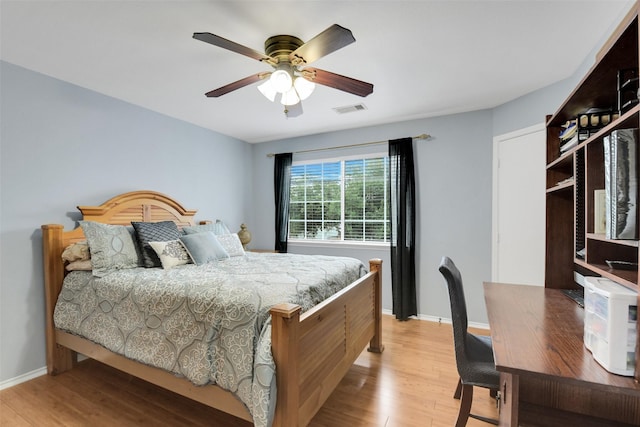 bedroom featuring light wood-style floors, baseboards, a ceiling fan, and visible vents